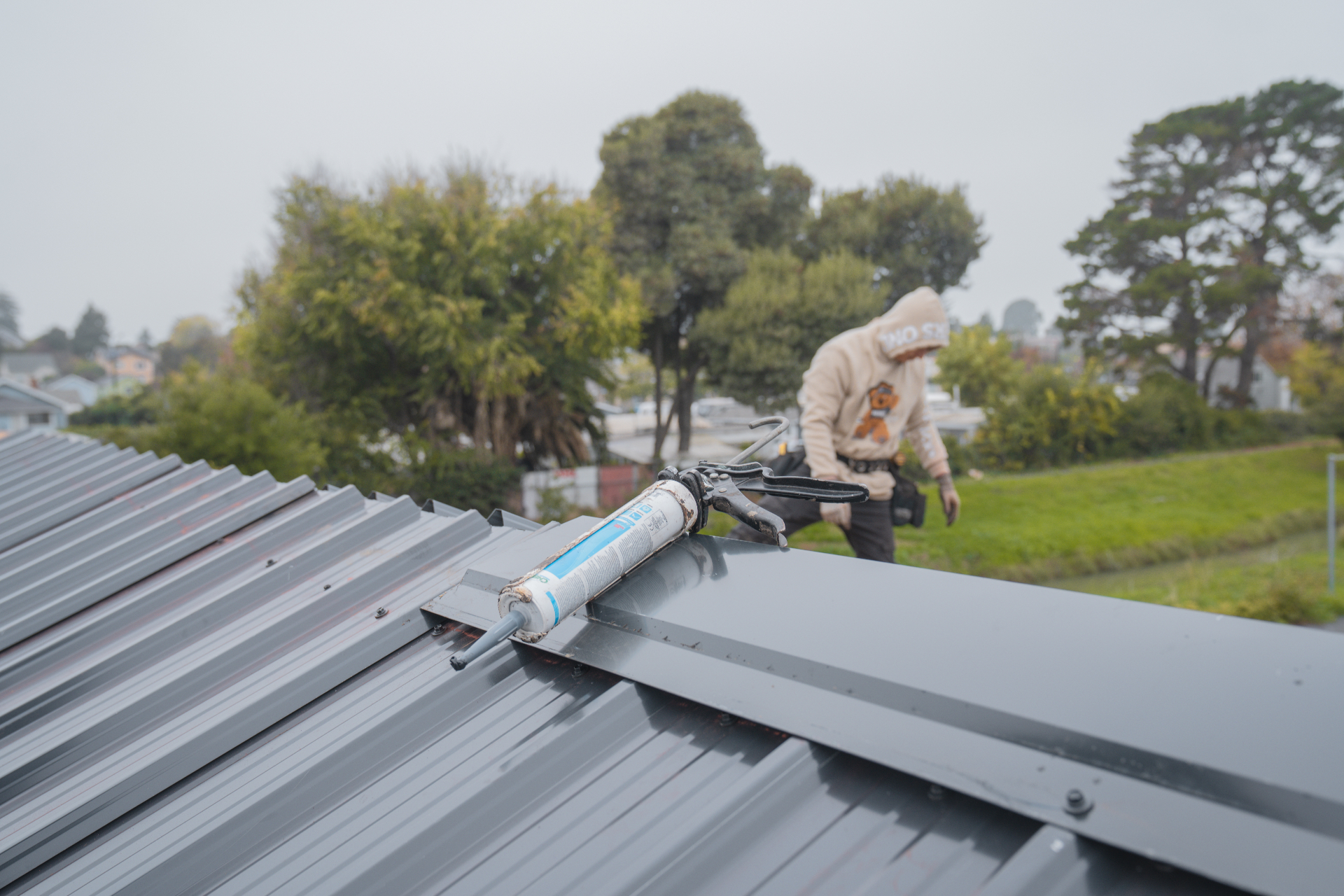 Close-up of ridge cap installation and sealant on a new metal roof