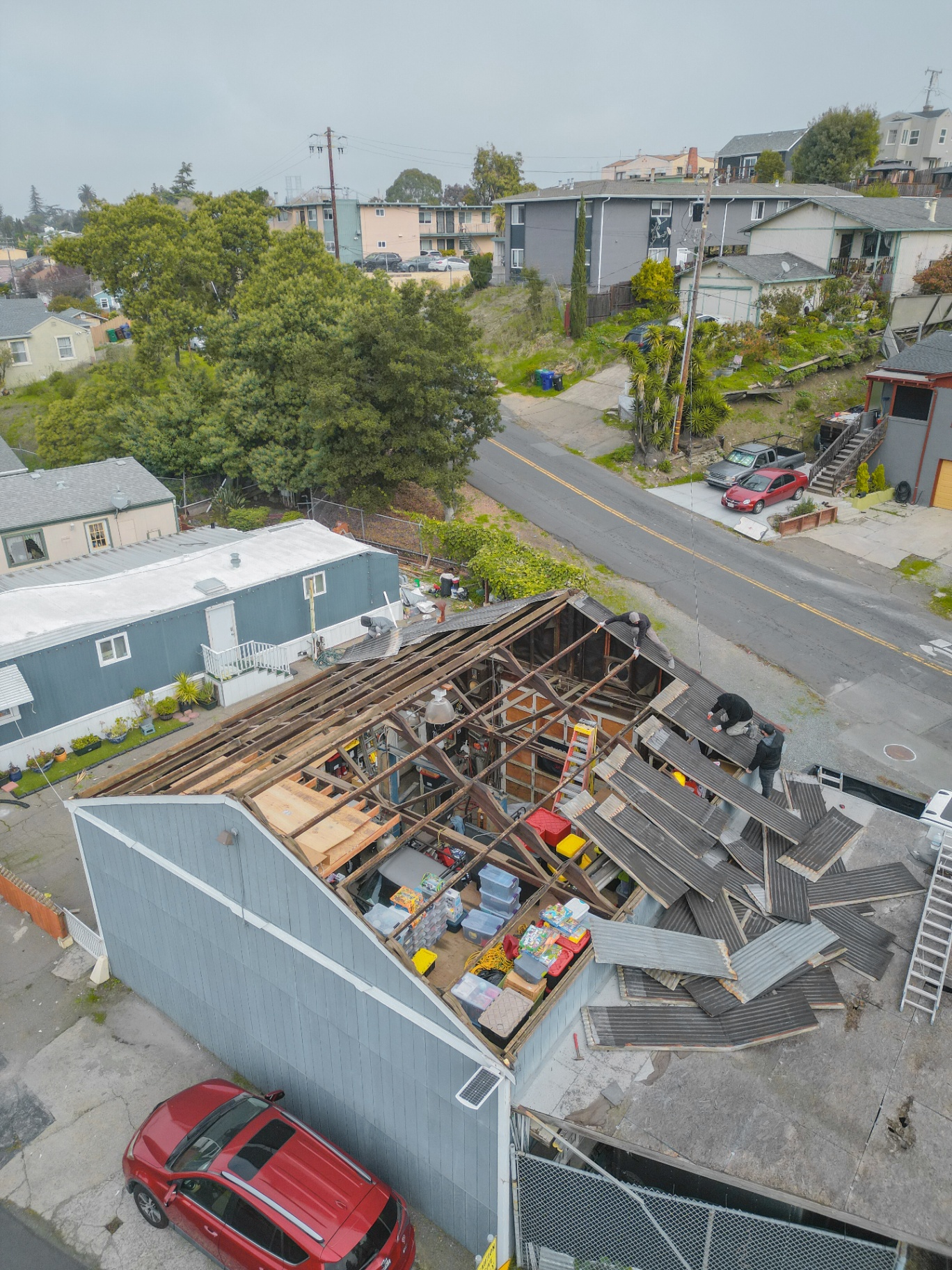 Top-down aerial showing exposed roof framing during demo