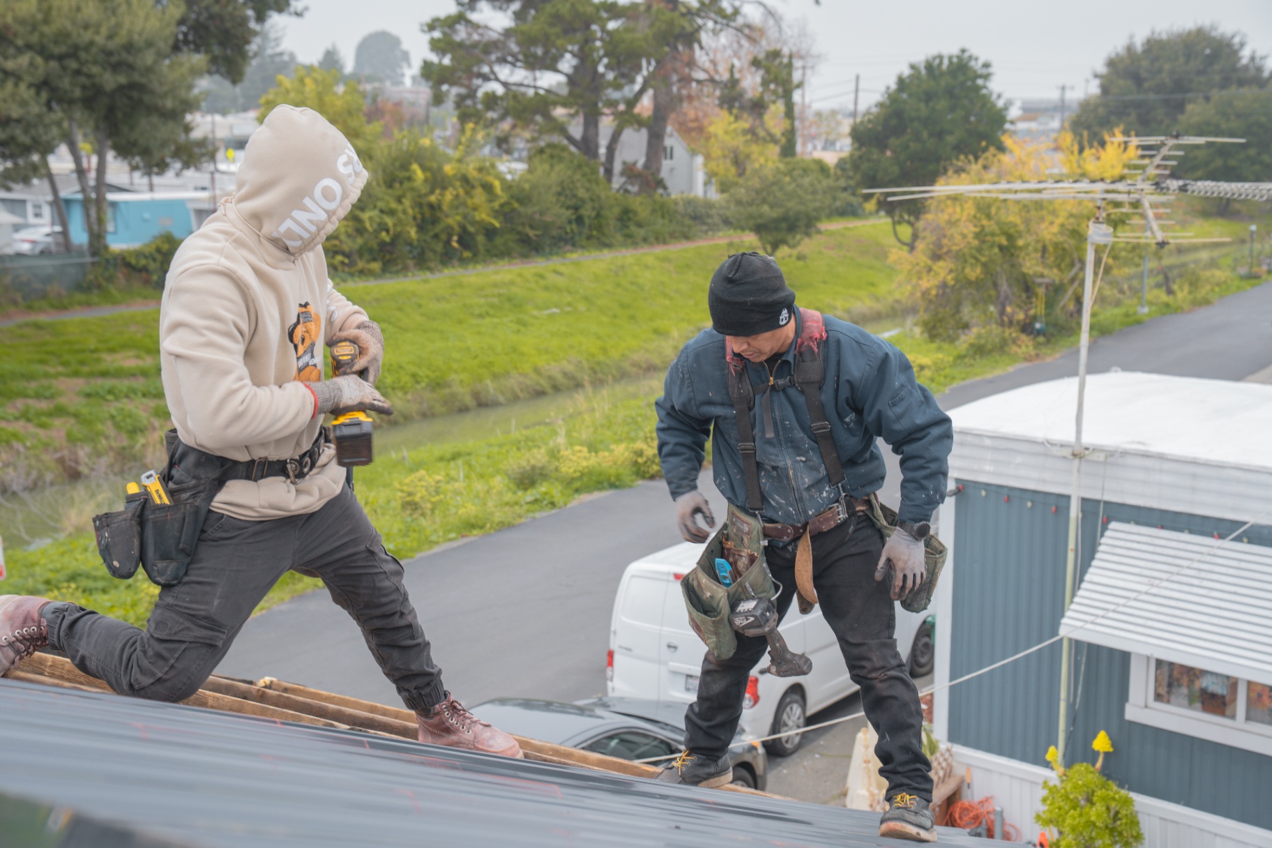 Crew fastening metal panels with cordless drills during install