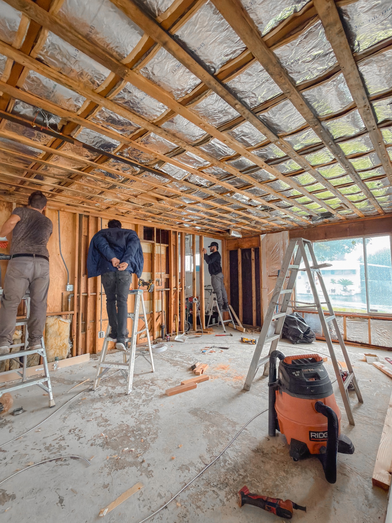 Crew working inside stripped interior during full remodel demolition