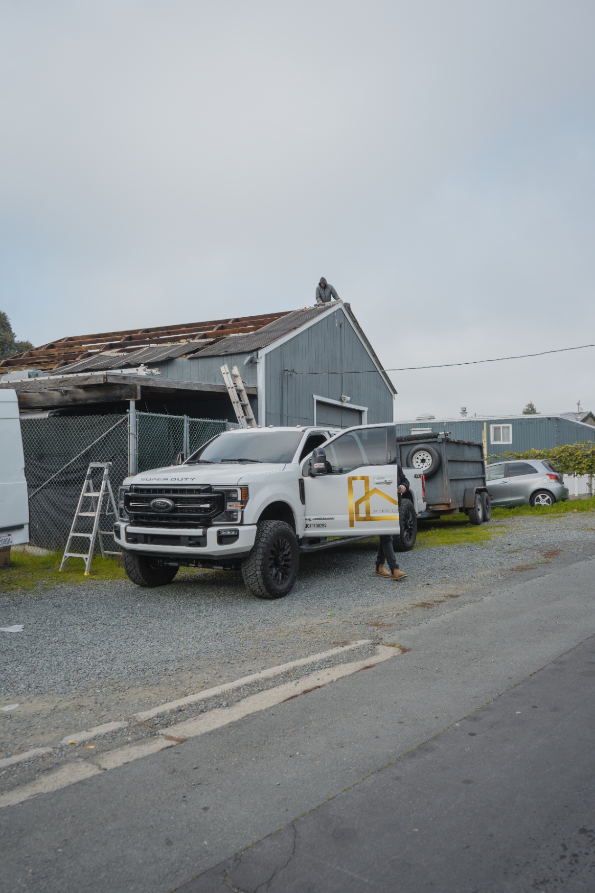 Company truck parked at shed roof demolition job site