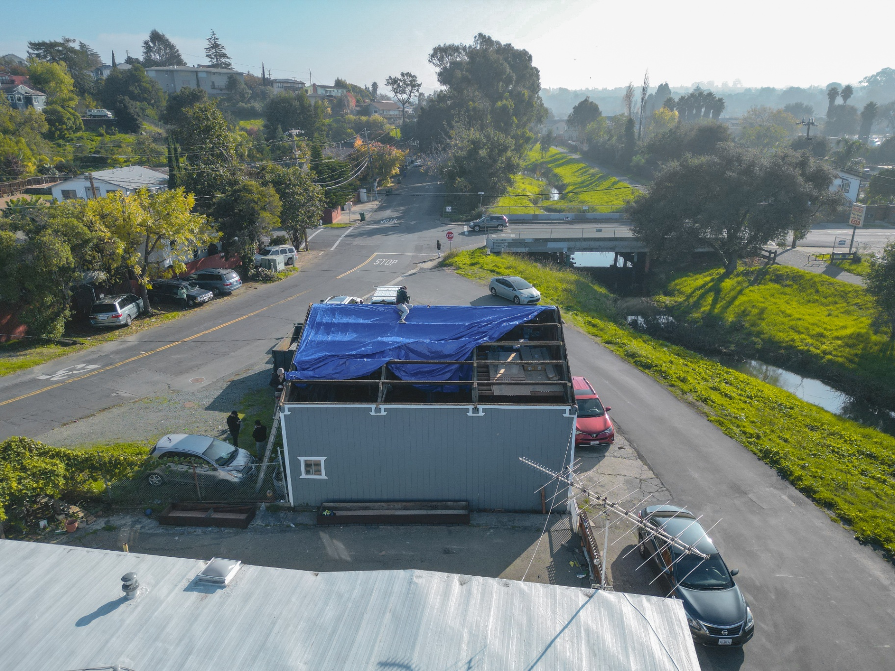 Street-facing drone view of roof protection tarp