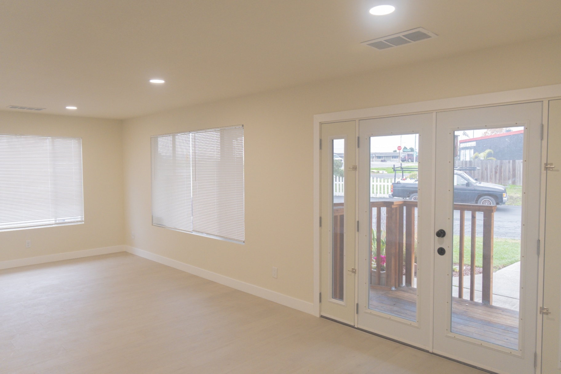Completed living area with new flooring, windows, and entry doors