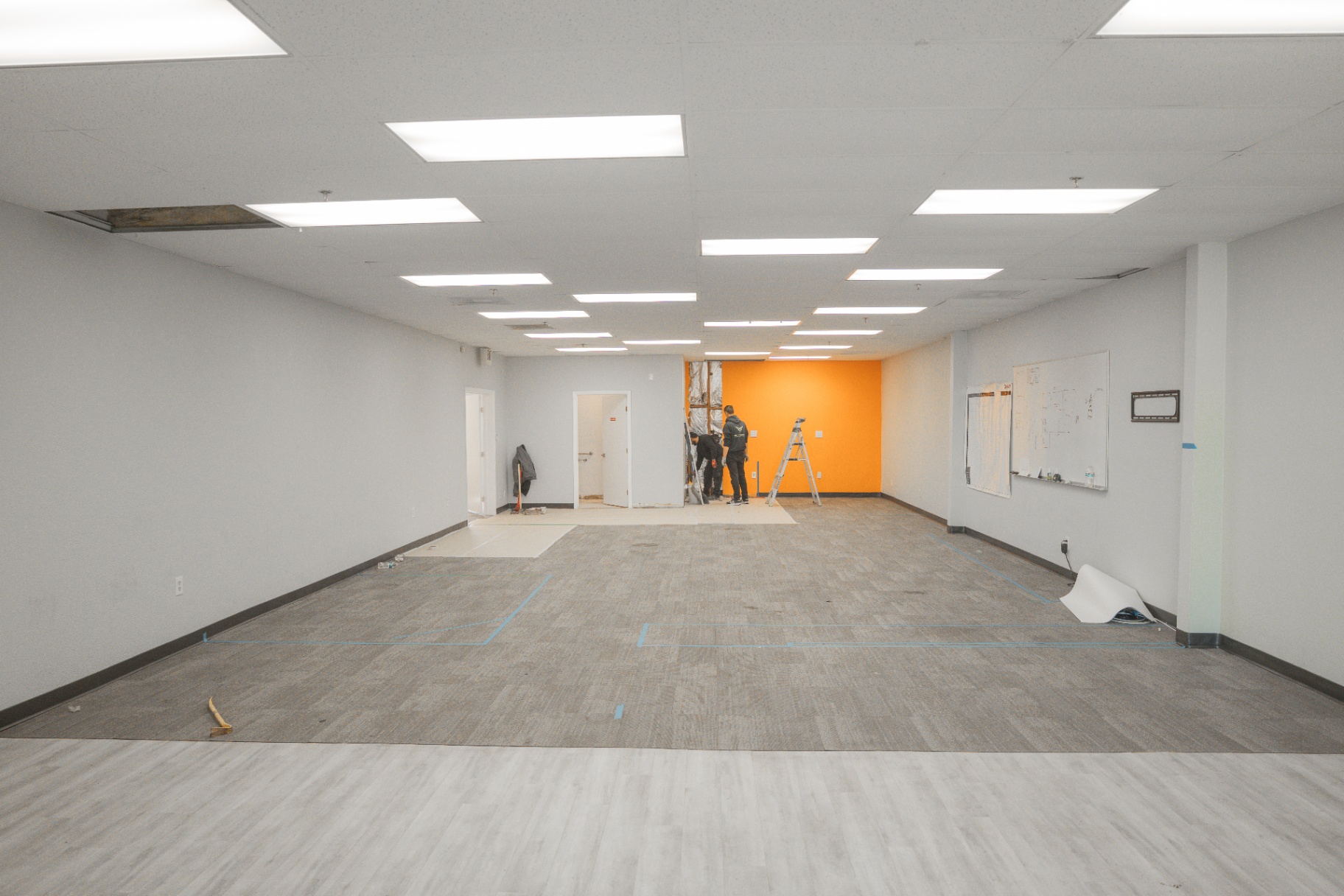Wide interior of commercial buildout with fresh orange accent wall