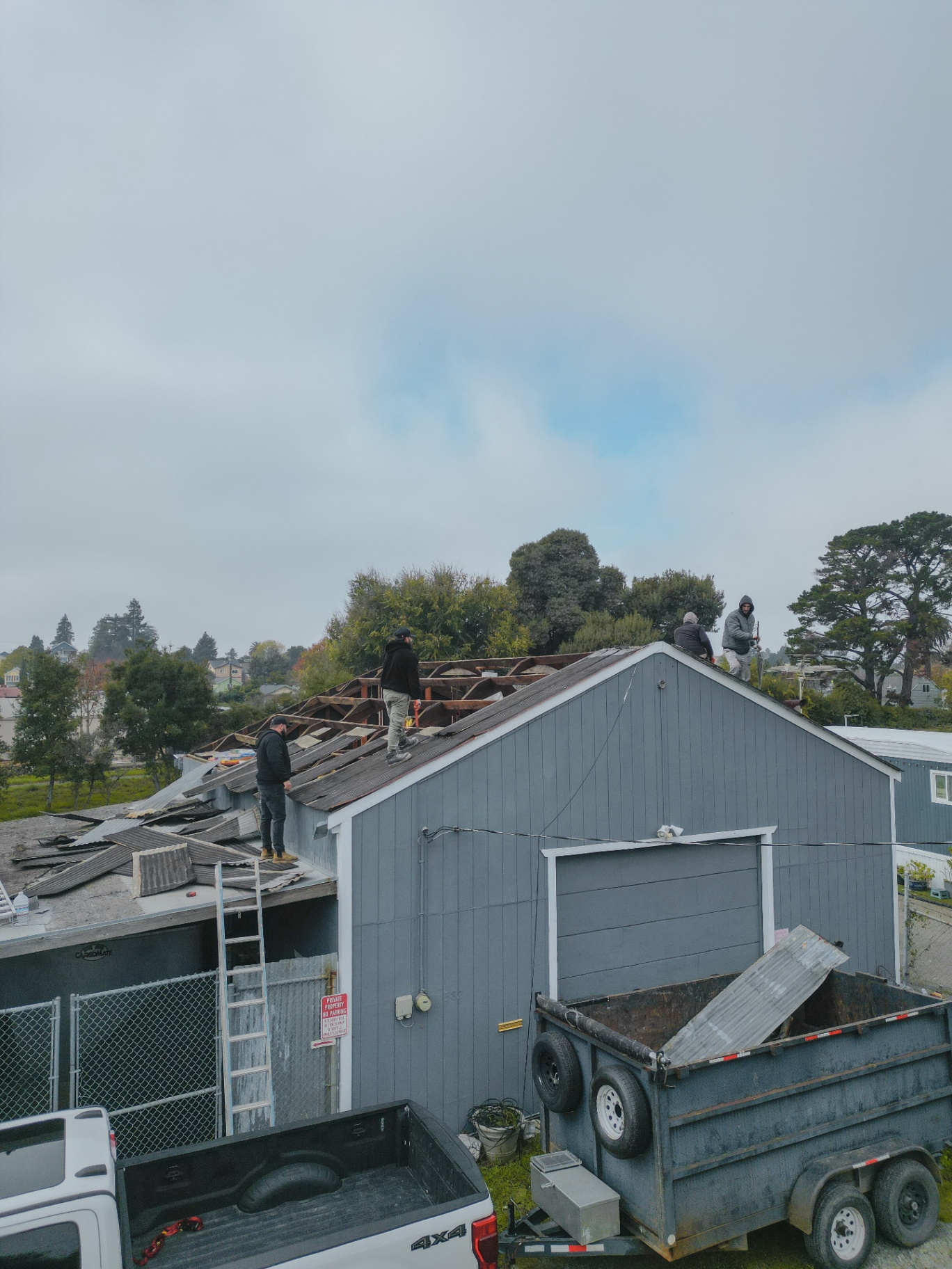 Side aerial of crew stripping the roof panels