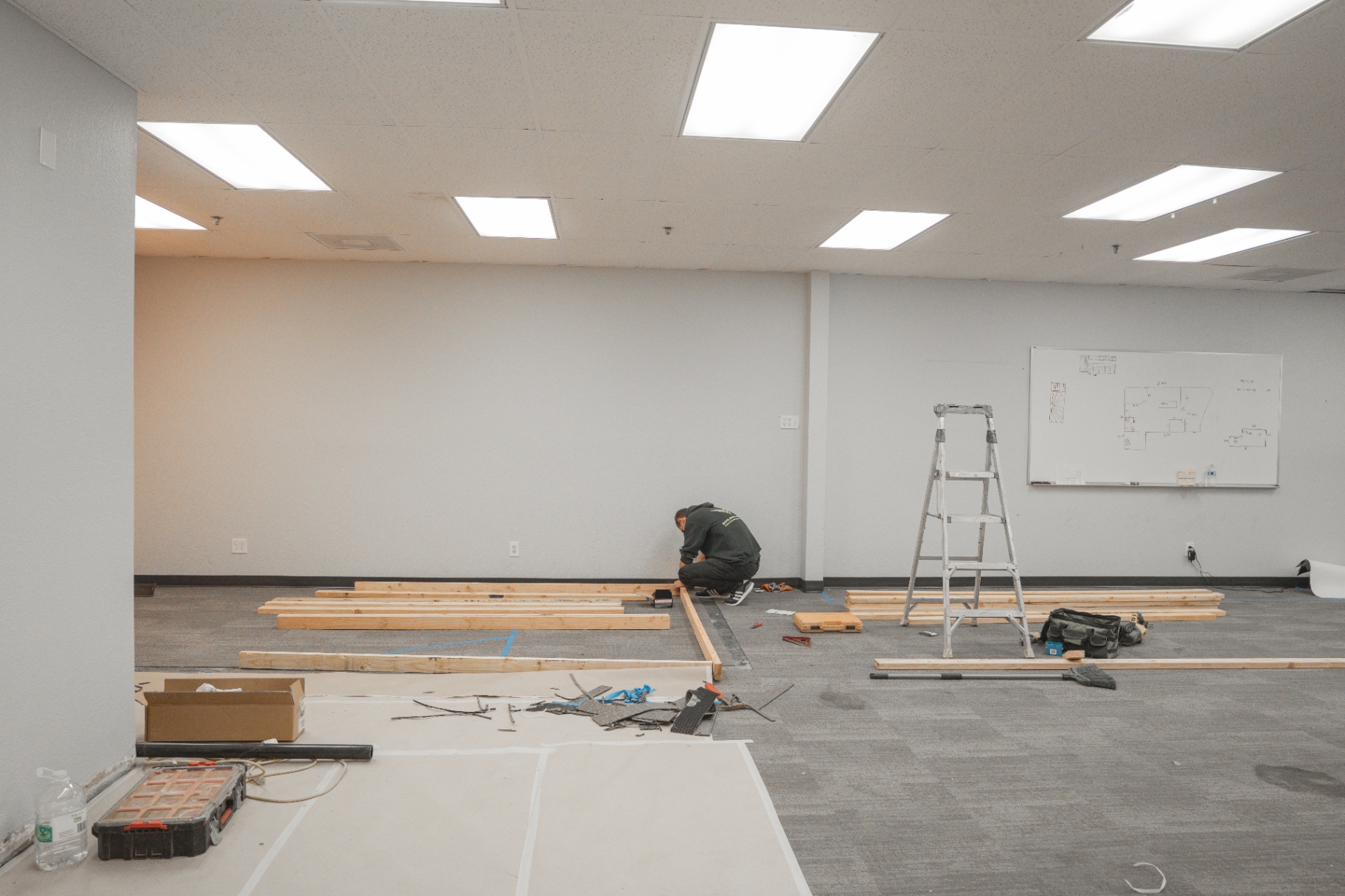 Lumber staged on floor as crew preps interior framing layout