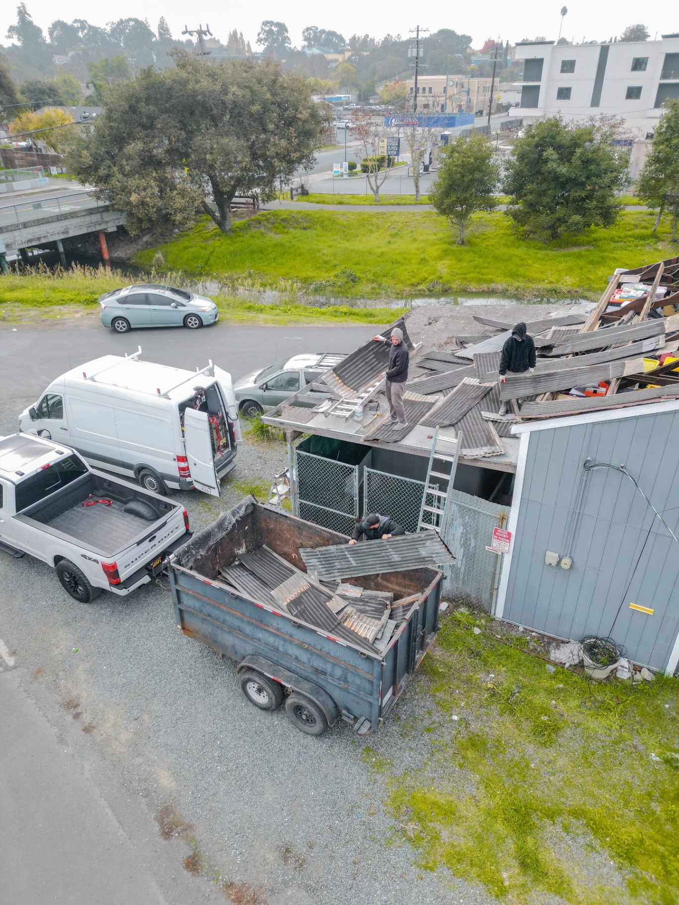 Crew loading removed roofing into the dump trailer