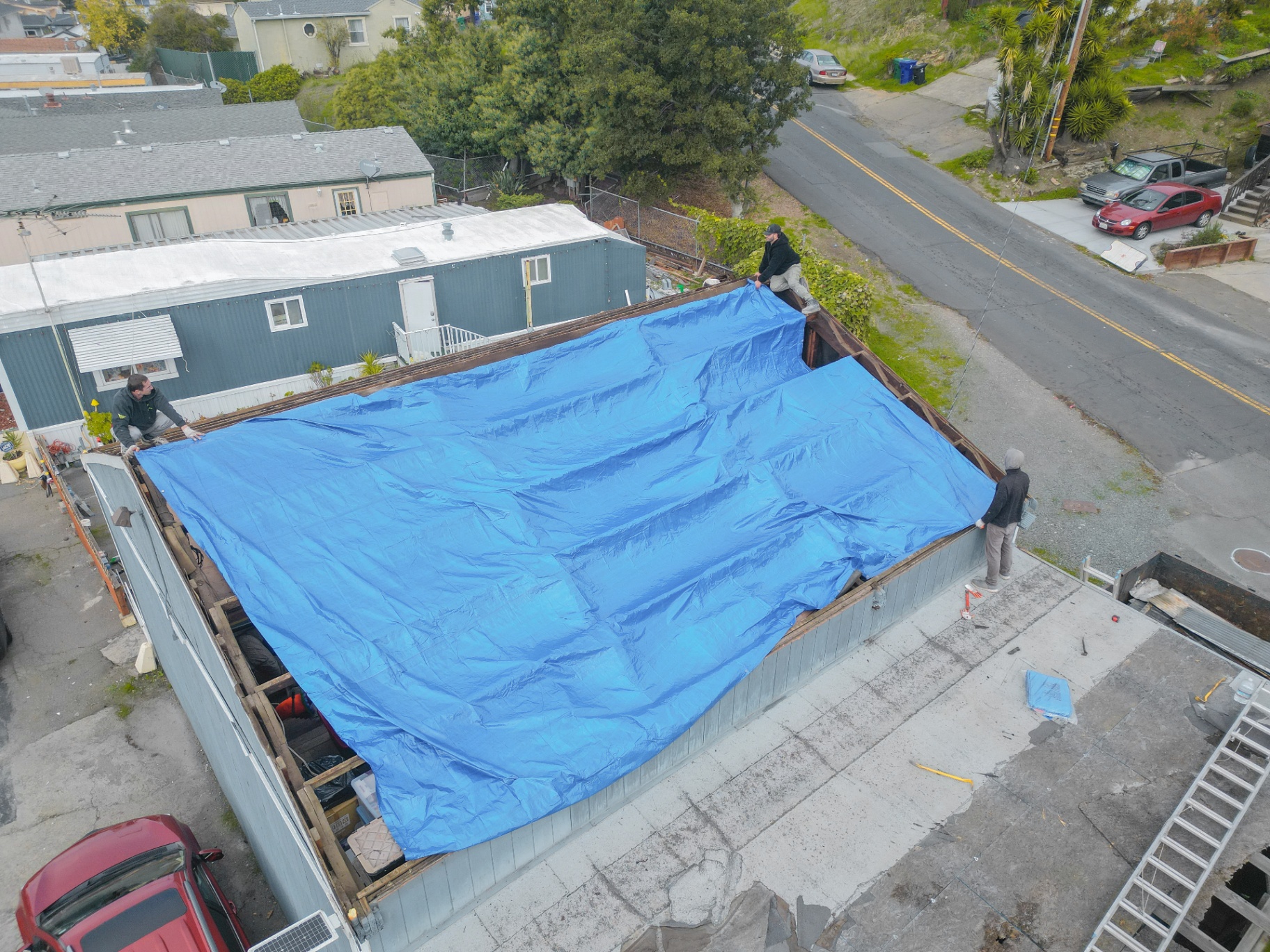 Crew tarping roof for weather protection