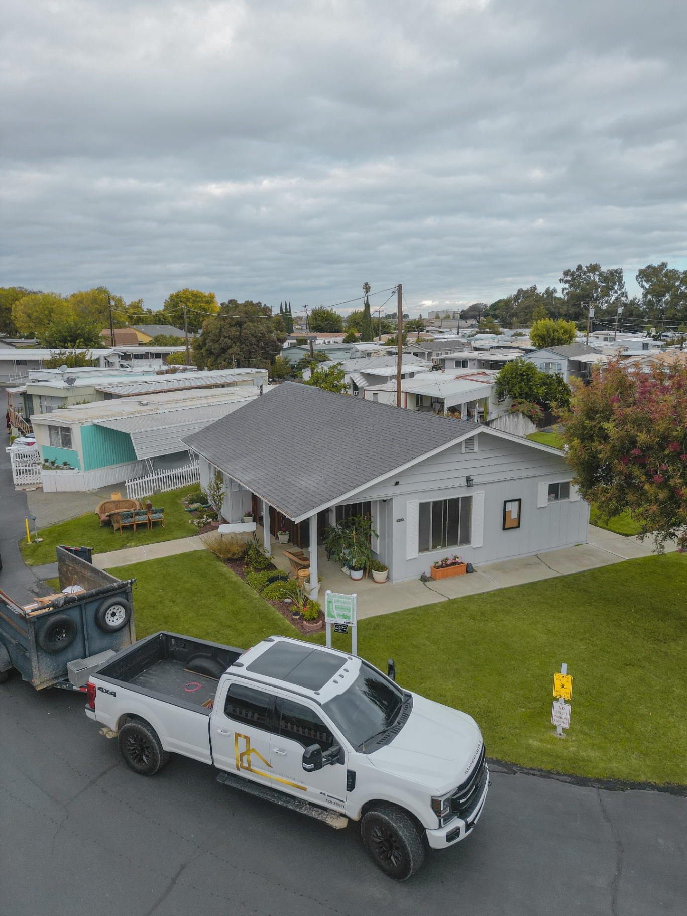 Aerial view of completed residential roof with company truck