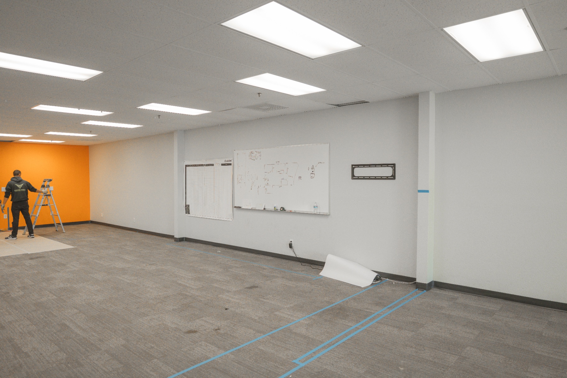 Commercial office buildout with whiteboards and orange feature wall