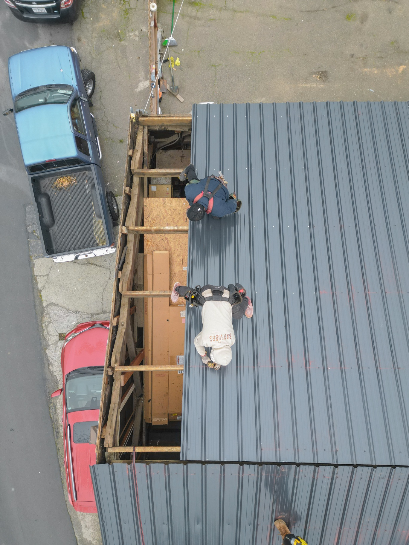 Close aerial of crew working on roof framing