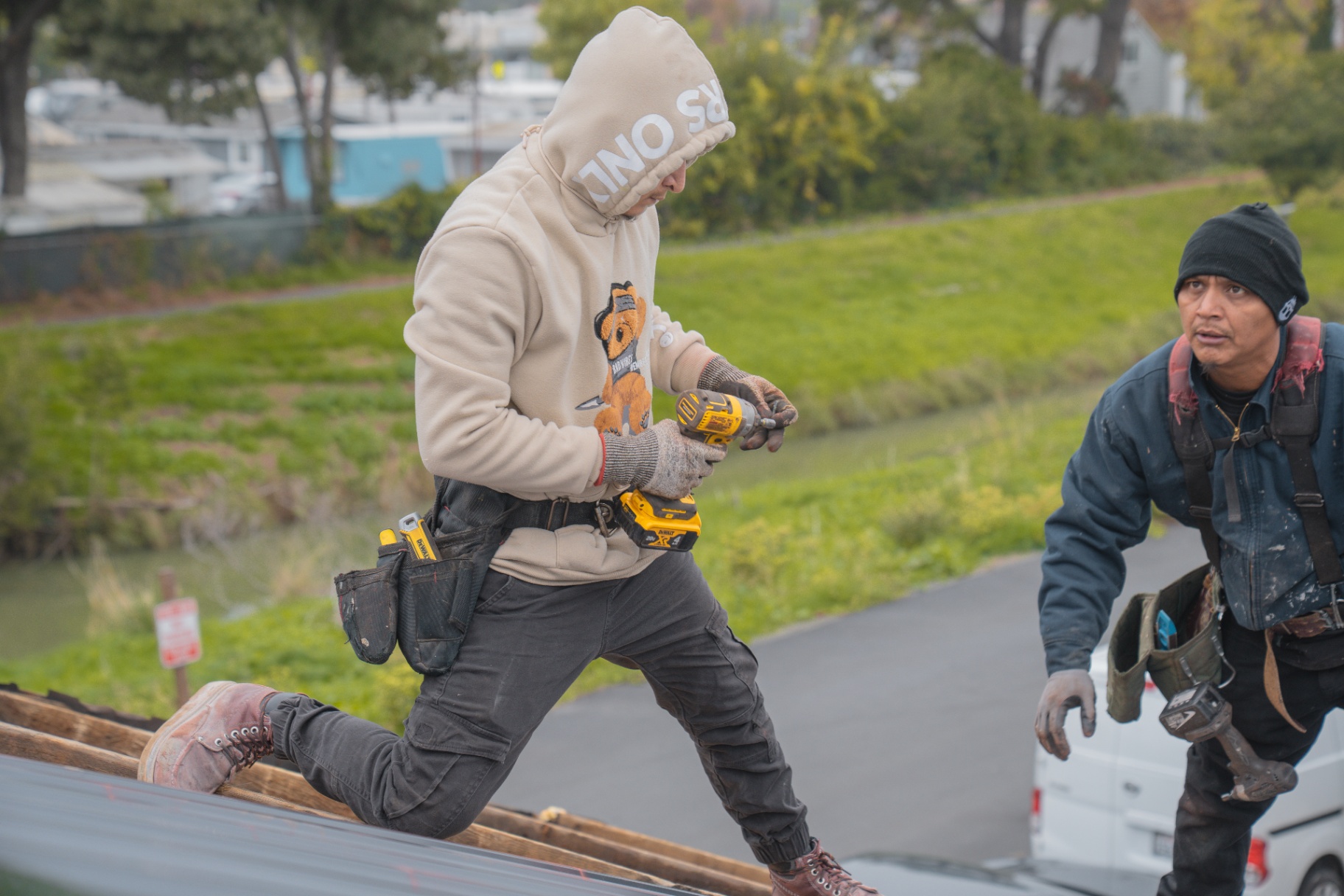 Close-up of roofer driving screws into a new metal roof