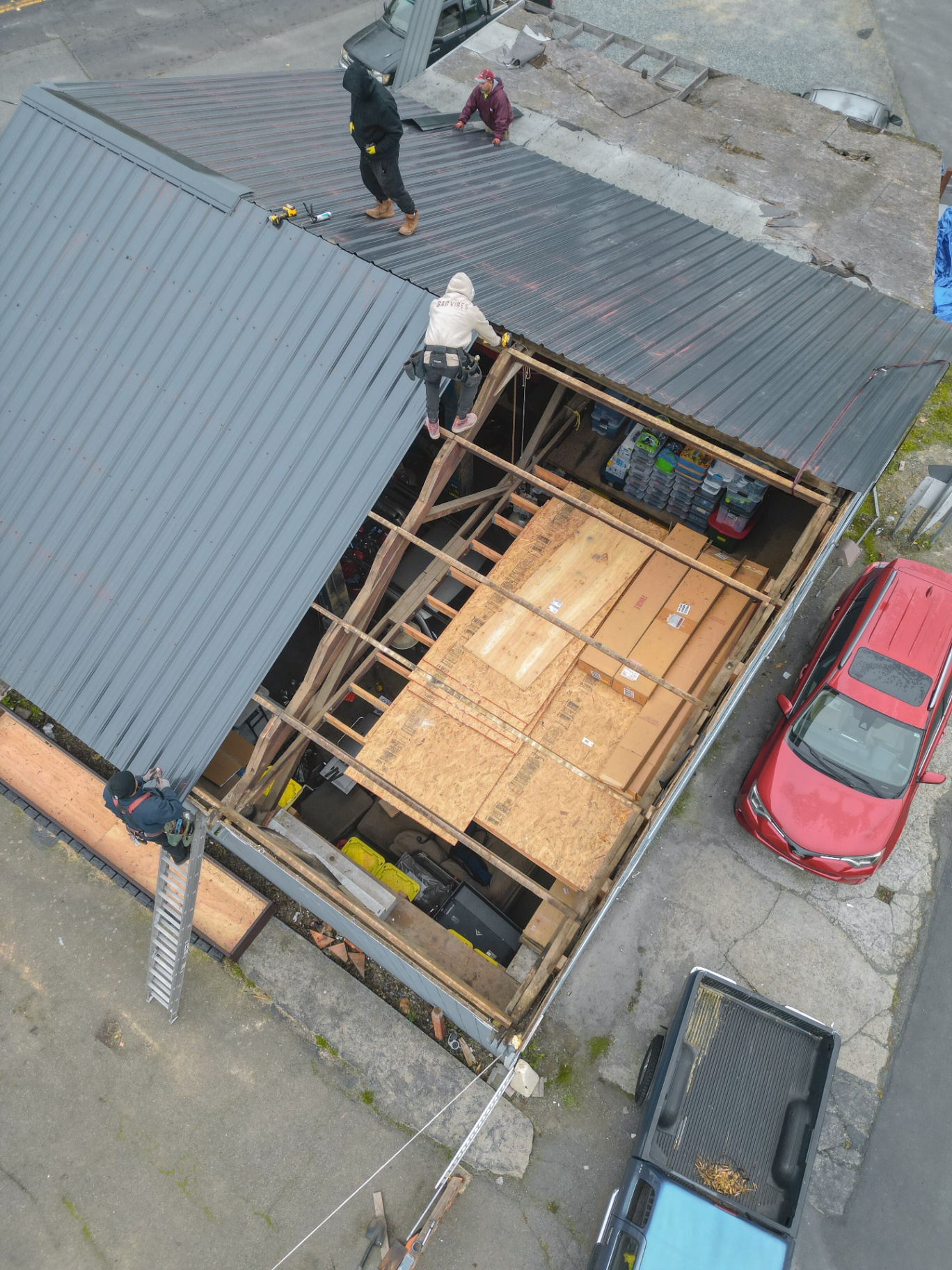 Crew laying new metal roof from above