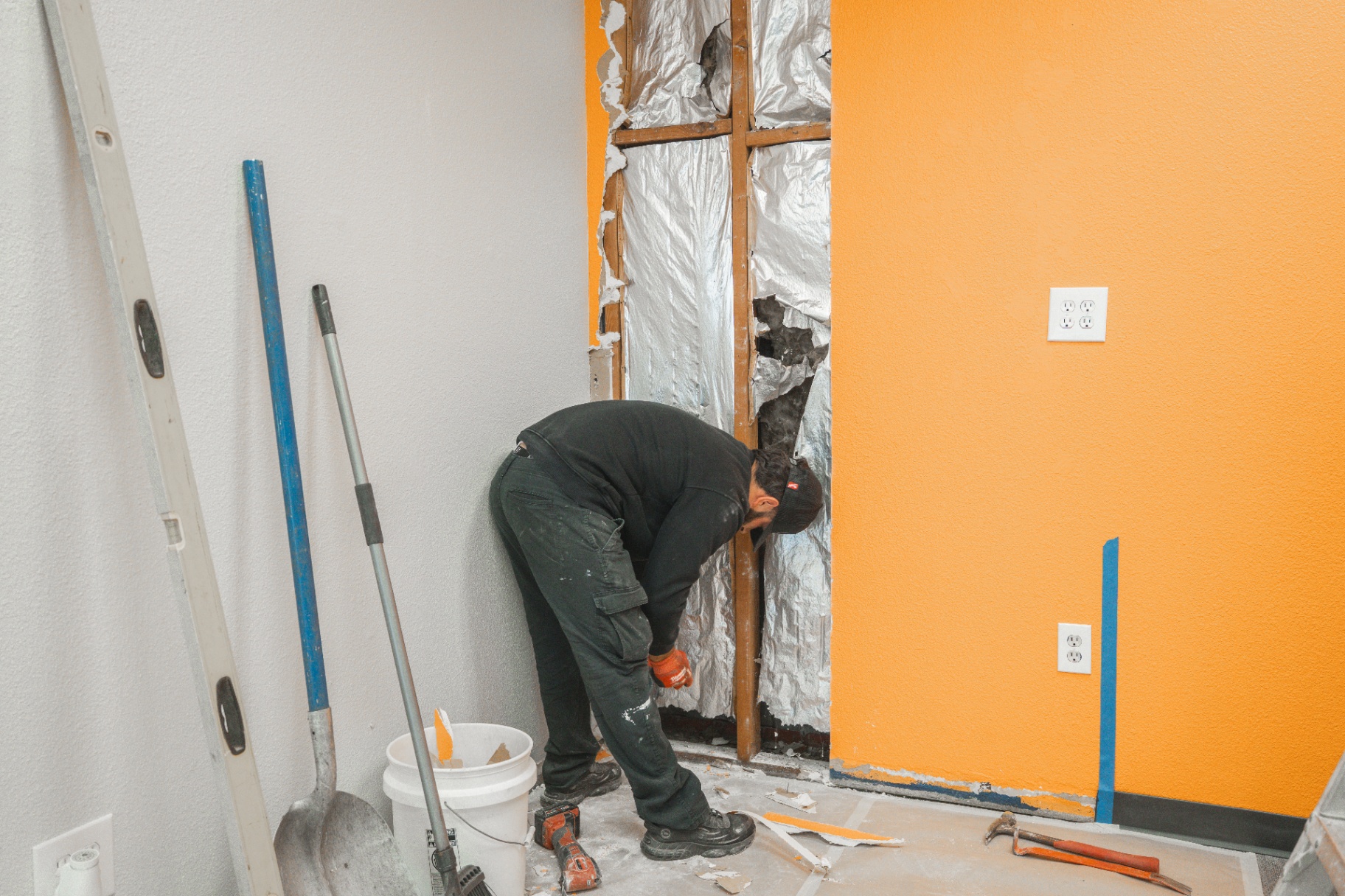 Interior demo with wall opened to expose framing and insulation
