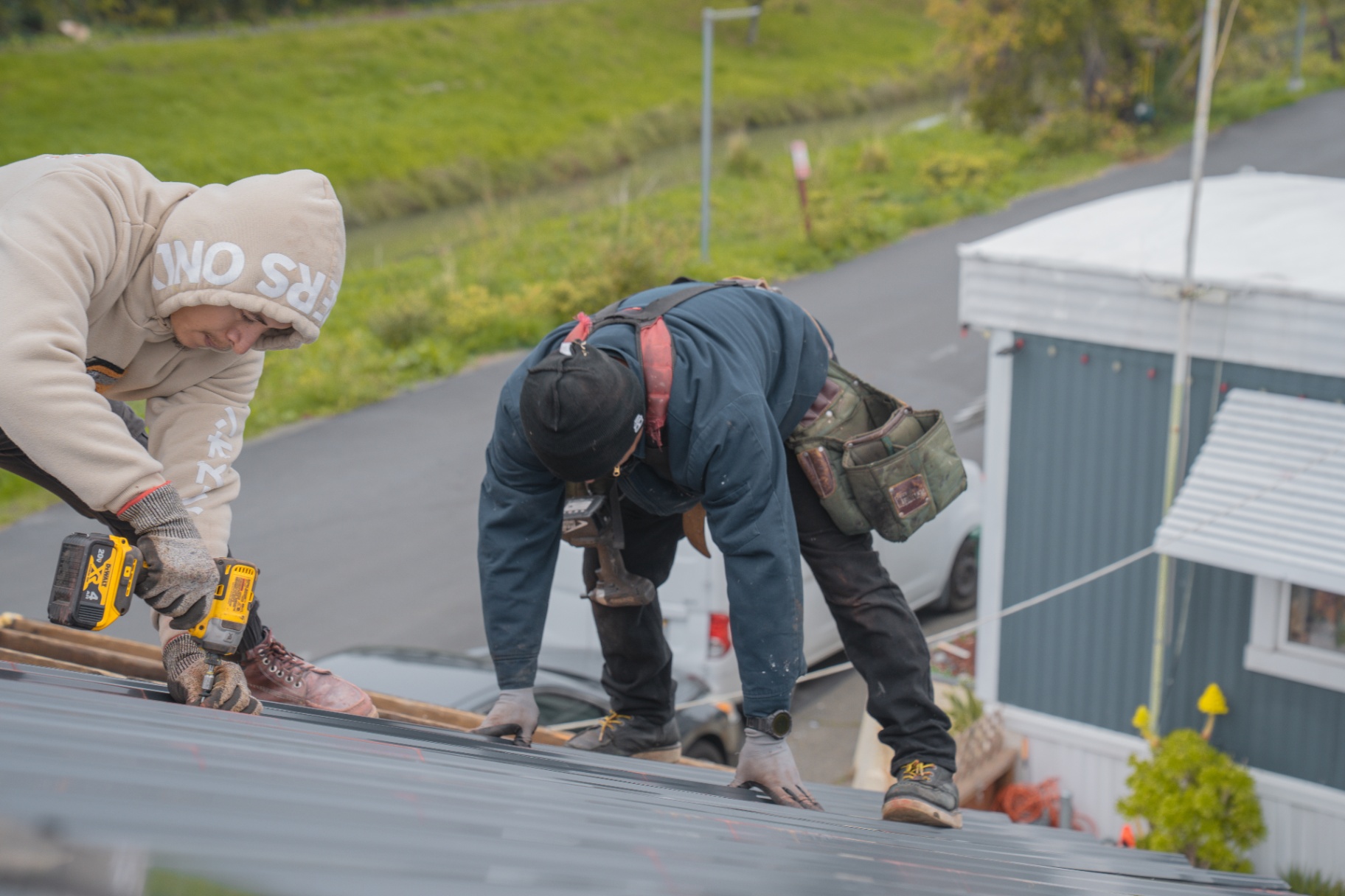 Crew fastening the new metal roof panels during installation
