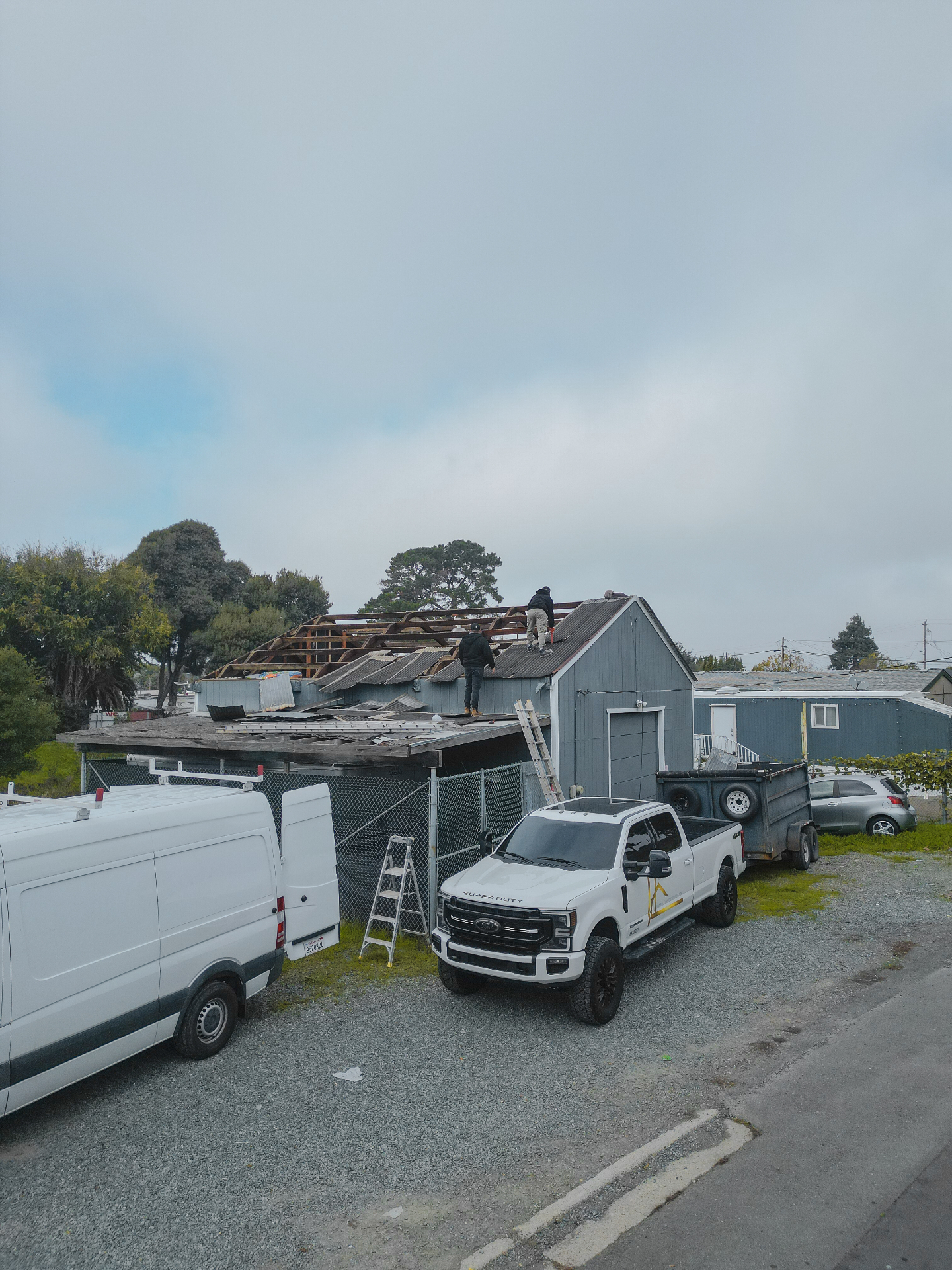 Wide job site view of the roof demolition in progress