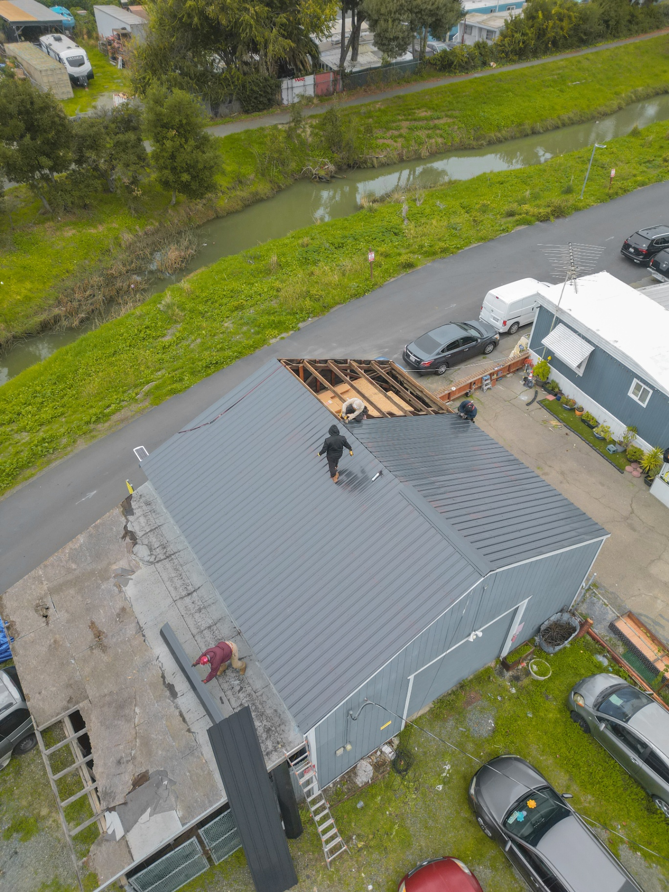 Aerial view of metal roof installation along waterway