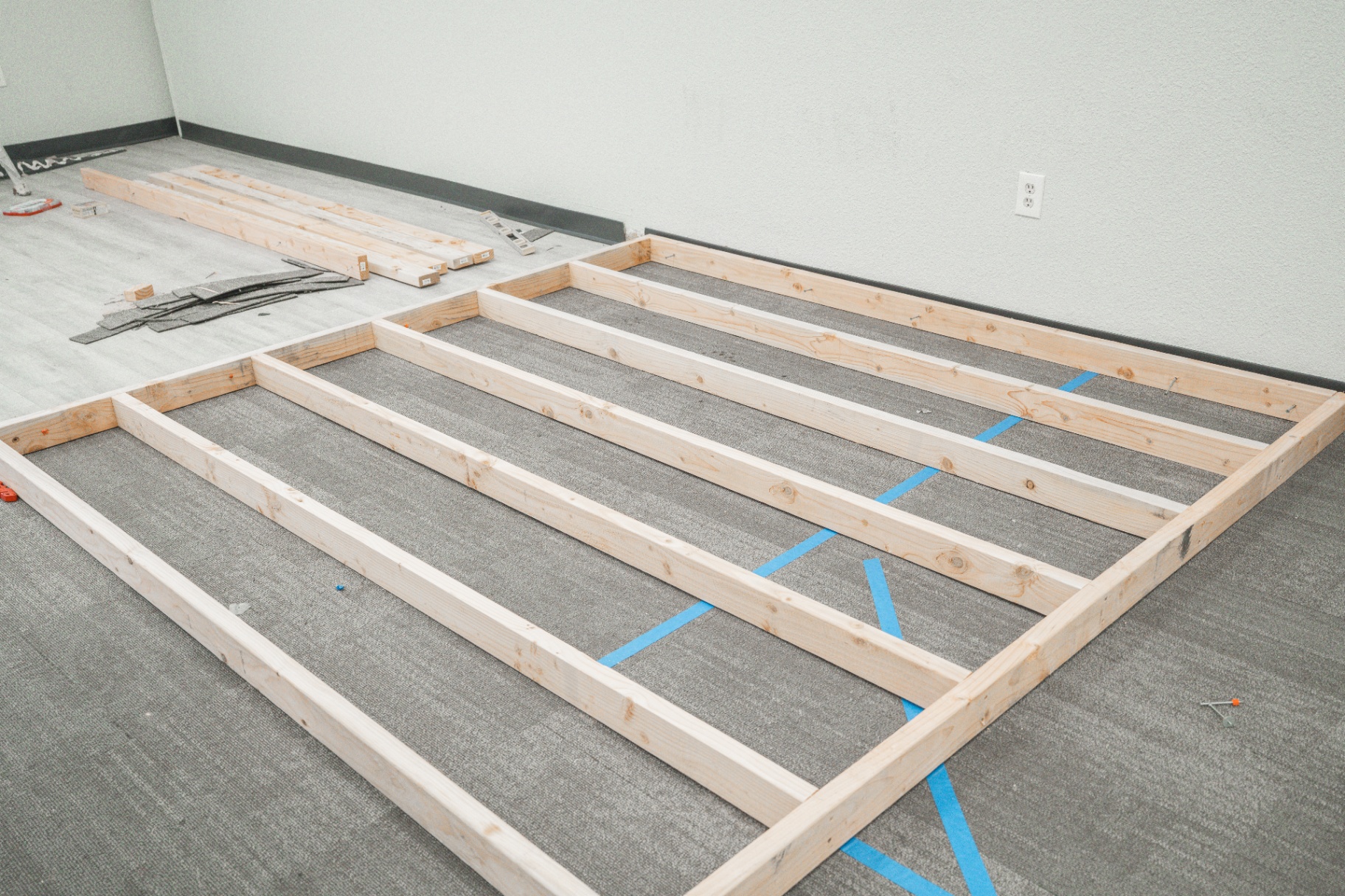 Wood subfloor framing laid out for raised platform during buildout